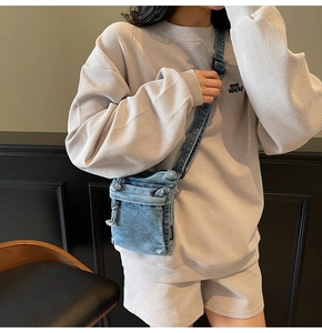 Dettaglio della borsa a tracolla in denim blu con set loungewear in maglia a nido d'ape