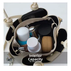 Détail montrant l'intérieur spacieux du sac seau couleur crème et sa poche intérieure