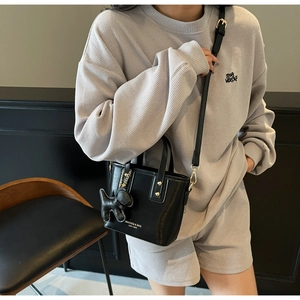 Chic black matte leather bucket bag shown with gold hardware and stylish strap details