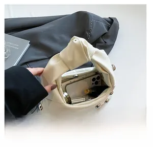 Interior capacity of white leather underarm bag with silver studs and knot handle