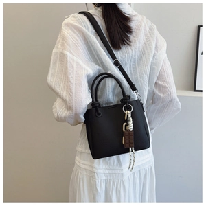 Sac seau noir avec pendentif chocolat présenté de dos sur un mannequin de mode
