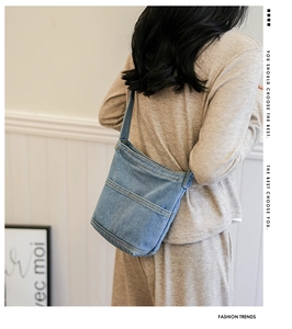 Sac bandoulière en denim bleu avec surpiqûres de style et poche externe ouverte