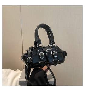 Détail du sac à main en cuir verni noir avec boucles argentées et style punk