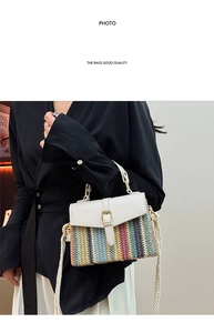 Macro detail of multi-color striped straw bag with white leather flap and golden buckle