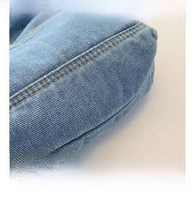 Vue détaillée du denim bleu clair avec doubles surpiqûres jaunes de qualité