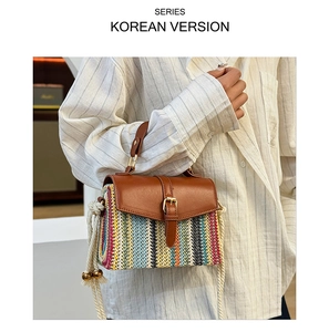 Detail of colorful woven straw shoulder bag with brown leather flap and metal buckle