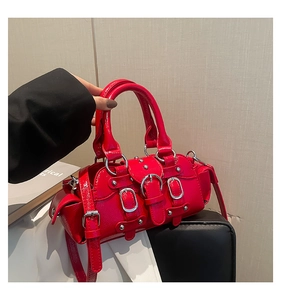 Gros plan détaillé du sac à main rouge verni avec rivets argentés et boucles décoratives