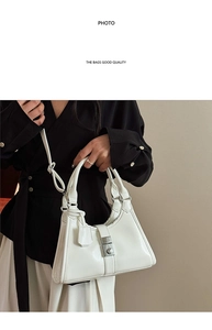 Detail of white patent leather handbag with silver clasp and twin top handles