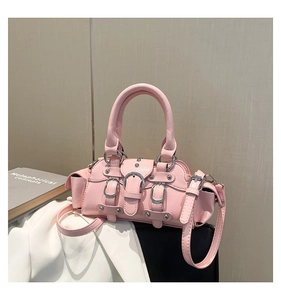 Détails d'un sac à main rose en similicuir avec des boucles métalliques et des rivets