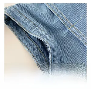 Détail du tissu en denim bleu clair avec texture sergé et double couture dorée