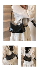 Detailed view of black patent leather crescent bag showing glossy texture and shoulder strap