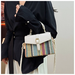 Close-up of vibrant striped straw bag featuring white leather buckle and rope strap