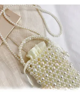 Close-up of pearl woven bucket bag with silk drawstring liner and beaded shoulder strap