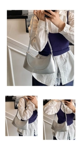 Detail of silver patent leather crescent bag with adjustable strap and zipper closure