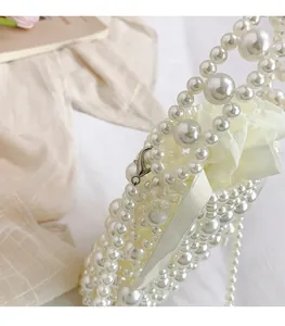Detail of handmade pearl bucket bag with silver metal lobster clasp and satin inner pouch