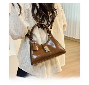 Brown glossy hobo bag with metal clasp shown in a casual lifestyle setting