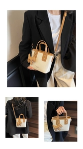 Detail view of cream and brown patchwork bucket bag with cute dog charm and shoulder strap