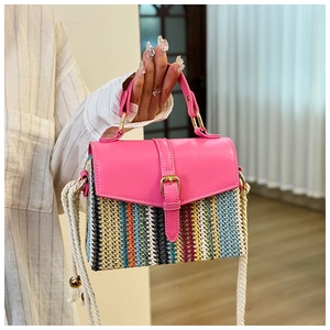 Detail of colorful woven straw bag with pink leather flap and thick white cotton rope strap