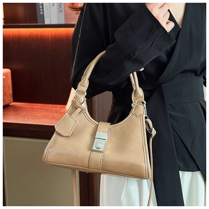 Detailed view of khaki shoulder bag with silver rectangular lock and leather hangtag
