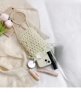 Detailed view of handmade pearl bucket bag showing storage space for phone and makeup