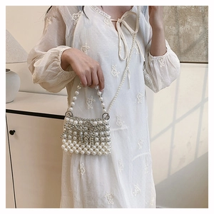 Detail einer eleganten Perlentasche mit Silberperlen und Perlenkette für Damen