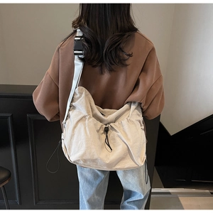 Close-up of drawstring nylon crossbody bag with adjustable wide strap and buckle