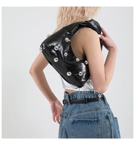Detail view of crescent shoulder bag featuring silver rivets and black glossy finish