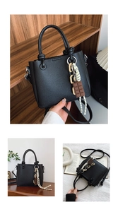 Détails du sac seau noir grainé avec chaîne décorative et pendentif chocolat élégant
