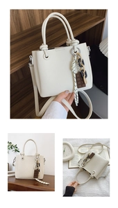 Sac seau blanc avec texture litchi, poignées à nœuds et pendentif en chocolat