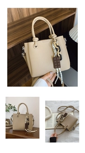 Détail du sac à main beige motif litchi avec poignée nouée et breloques décoratives