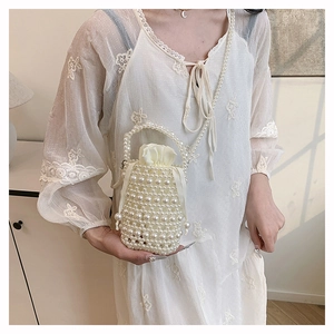 Exquisite pearl woven bucket bag with drawstring interior and pearl shoulder strap on model