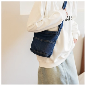 Détail du sac bandoulière en denim bleu marine vintage avec coutures contrastées et style