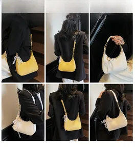 Détails du sac demi-lune avec pendentif nœud en perles et texture cuir grainé