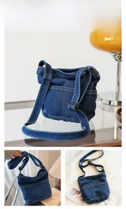 Vue détaillée du sac bandoulière en denim bleu foncé avec poches et surpiqûres jaunes