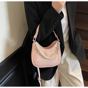 Roze lakleren halve maan tas met een parel hartketting en lange verstelbare schouderriem