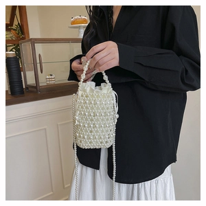 Close-up of woven pearl bucket bag with drawstring silk liner and long pearl chain