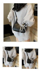 Détail du sac en cuir grainé avec nœud en dentelle et pendentif en perles chic