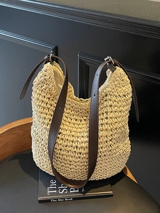 Handwoven straw shoulder bag with adjustable brown leather straps for beach holidays