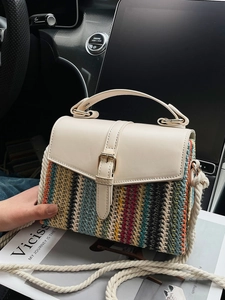 Fashionable straw shoulder bag with colorful stripes and cream leather flap in car interior