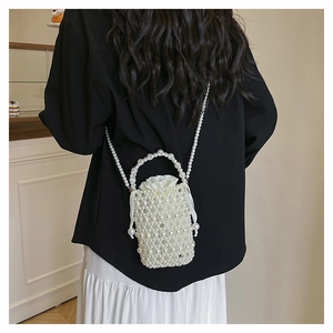 Detailed view of handmade pearl woven bucket bag with silk drawstring liner on a model