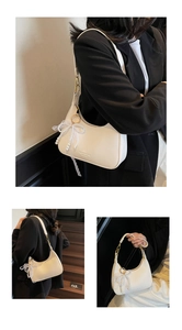 Détail du sac demi-lune en cuir blanc avec nœud en dentelle perlée et boucles dorées