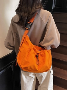 Bright orange nylon messenger bag with drawstring adjusters and wide shoulder strap