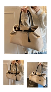 Detail view of large apricot woven tote bag with black leather straps and metal D-ring buckle