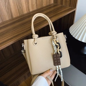 Sac seau minimaliste en cuir kaki avec poignée à nœud et pendentif chaîne décoratif