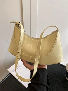 Glossy light yellow patent leather crescent underarm bag with NO FILTER text