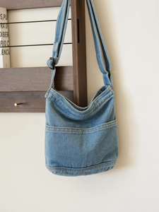 Sac bandoulière minimaliste en jean bleu délavé avec sangle et doubles poches avant