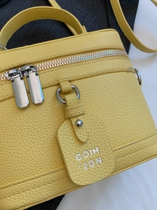 Yellow litchi texture leather box bag with silver zippers and top handle