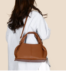 Caramel brown dumpling cloud bag showing pebble leather texture and crossbody strap