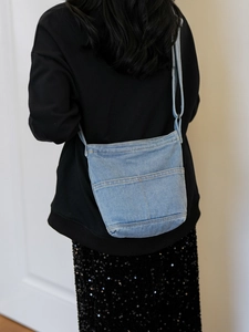 Sac bandoulière minimaliste en jean bleu clair sur mannequin pour un look décontracté
