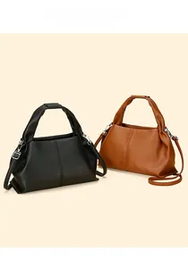 Close-up of cloud-shaped dumplings bags in black and caramel leather with lychee texture